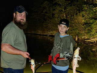 Father and son gigging two sucker fish on Firehouse Bowfishing boat in Missouri Title: Sucker Gigging Missouri – Firehouse Bowfishing