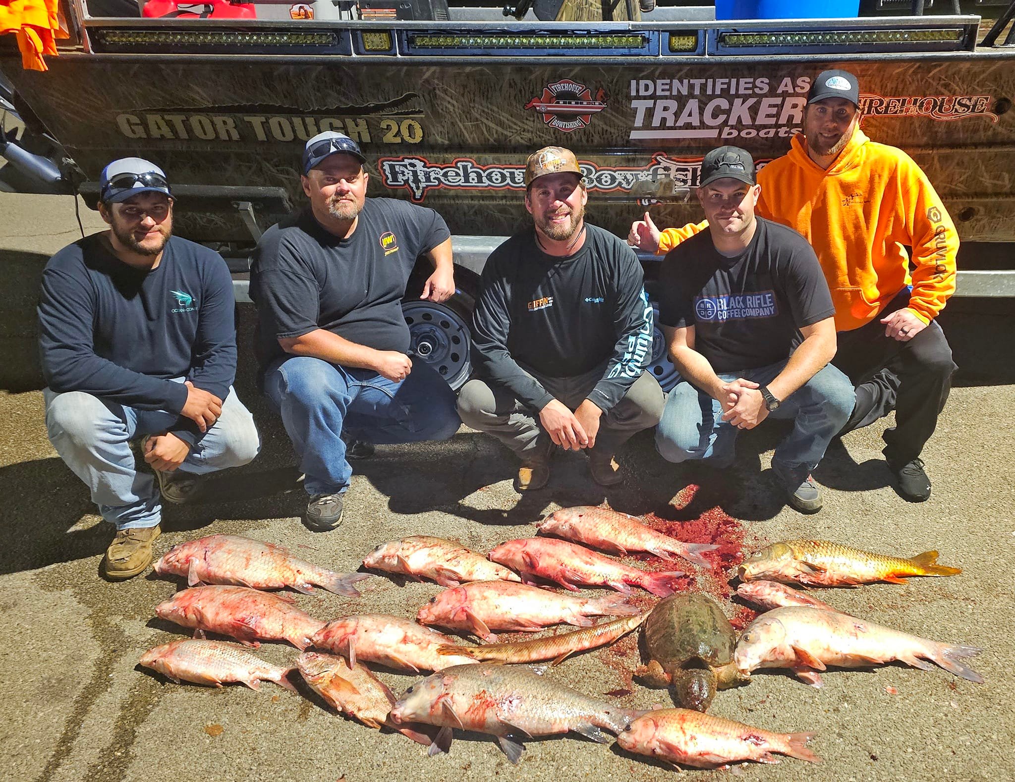 Group of construction workers showing their bowfishing catch in front of a boat at Lake of the Ozarks